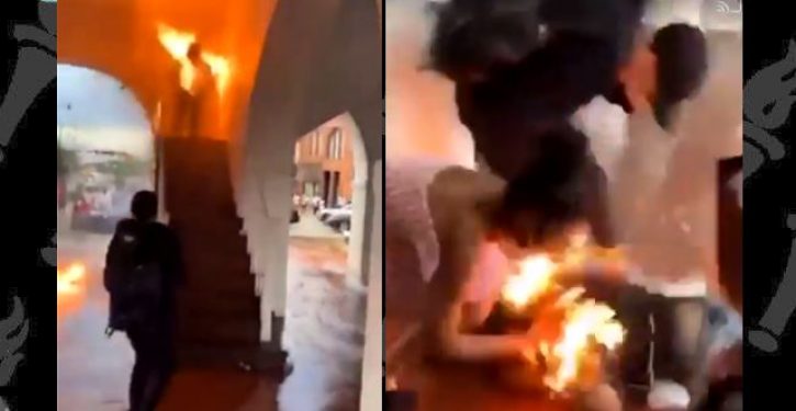 A rioter attempting to torch a historic building manages to set himself on fire